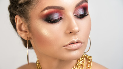 Beauty portrait of young girl with the shining smooth healthy skin of person bright expressive smoke-coloured make-up and gold on lips