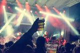 Fototapeta Sawanna - Raised beer glass at a concert.