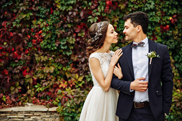 Bride holds her veil on her hand while she hugs groom