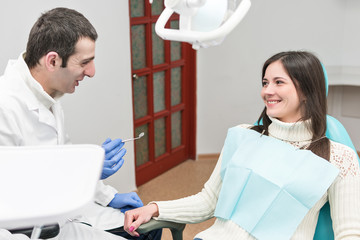 Canvas Print - Dentist male persuades the patient female to examine the teeth