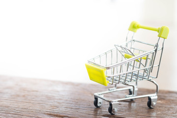 Shopping cart on wood background, shopping online, space for text.