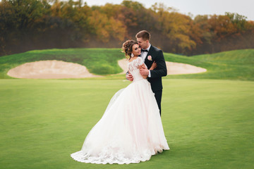 Beautiful bride and groom walking in Autumn Park