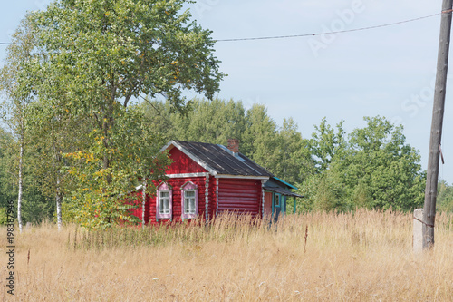 Fotografia, Obraz A small wooden log house in a village situated in the forest.