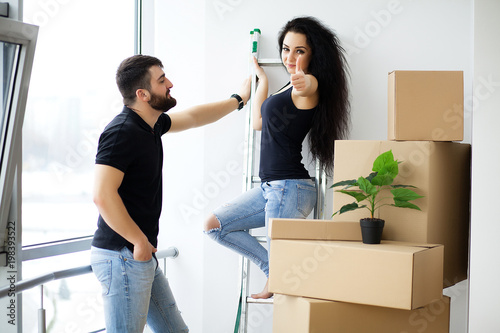 Poster Pretty young couple moving in new home.