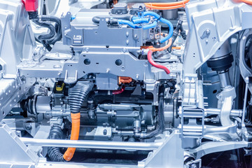 Chassis of the electric car with powertrain and power connections closeup. Blue toned.