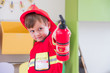© weedezign - Caucasian boy kid dress up to fireman and use speaker at roll play classroom,Kindergarten preschool education concept