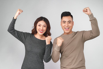 Smiling happy asian couple holding both thumbs up