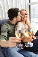 Wall Mural - Smiling young loving couple drinking alcohol white wine champagne.