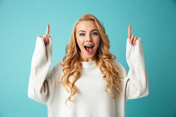 Wall Mural - Portrait of an excited young blonde woman in sweater