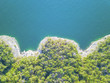 Aerial view bluffs at Lake Travis, Austin, Texas, USA. Trees and cliff rock wall coming out of water from above. Vast blue ocean crystal background, moderate waves looking straight down, green forest