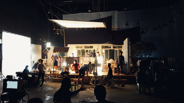 silhouette group of people working in big production studio for shooting or filming tv commercial wi