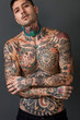 Handsome tattooed man posing bare-chested