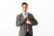 © Drobot Dean - Smiling business man in jacket corrects his tie
