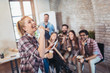 © Mediteraneo - Business people making team training exercise during team building seminar singing karaoke.