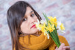 young brunette woman with bouquet of daffodils