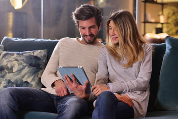 A married couple in love videocall their parents using a tablet, to announce the birth of their son showing the ultrasound. Concept of: family, birth, life, love