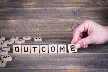 Outcome. Wooden letters on the office desk, informative and communication background