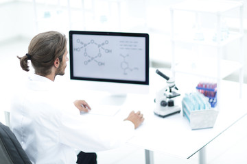 Young man working in a medical lab using a computer