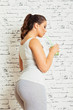 © BigLike Images - Gorgeous young fitness woman with green smoothie. Closeup, studio lighting, brick wall background.