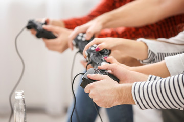 Wall Mural - Young people playing video games at home, closeup