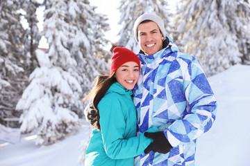 Canvas Print - Happy couple at beautiful snowy resort. Winter vacation