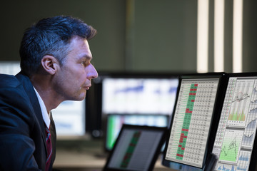 Poster - Stock Market Broker Analyzing Graph On Multiple Computer Screen