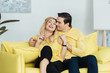 © LIGHTFIELD STUDIOS - Embracing man and woman sitting on yellow sofa