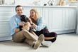 © LIGHTFIELD STUDIOS - Man and woman playing with their dog on kitchen floor