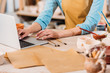 © LIGHTFIELD STUDIOS - cropped view of woman working with laptop in pottery workshop