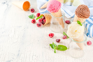 Wall Mural - Summer sweet berries and desserts, various of ice cream flavor in cones pink (raspberry), vanilla and chocolate with mint on light concrete background copy space