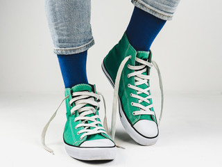 Stylish, bright, green sneakers and funny, happy socks on a white background. Sport, style, beauty, good mood