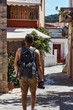 young man traveller with camera and backpack walking through the foreign city, Creta, Greece
