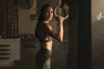 Wall Mural - Woman holding gymnast rings at the gym