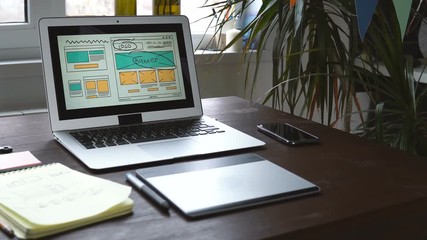 Web developer sitting at the table making a sketch of the future site. Working remotely from a home office.