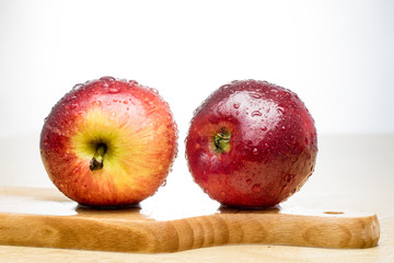 Tasty and ripe apples. Fruit sprinkled with water on a wooden kitchen table.