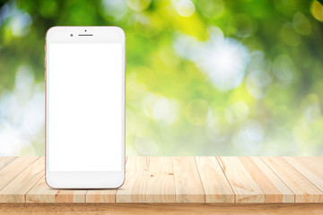 Poster - Blank smartphone on wood table with green bokeh nature background.
