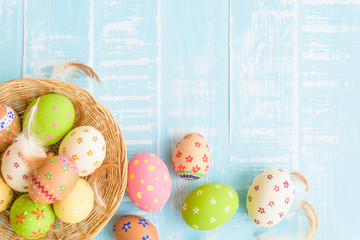 Happy easter! Colorful of Easter eggs in nest on pastel color bright green and white wooden background.