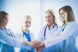 © lenets_tan - Doctors and nurses in a medical team stacking hands