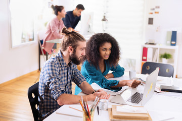 At office of a startup, a young multi-ethnic team works on diffe