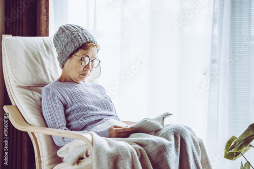 窓際の椅子に座って本を読むシニア女性 Stock Photo Adobe Stock 窓際の椅子に座って本を読むシニア女性 Stock Photo Adobe Stock