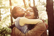 © Mladen - African American mother and her daughter hugging with daughter in forest.