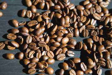 Coffee beans on black wooden background.