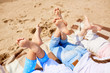 © pressmaster - Soles of bare feet of girls lying on sandy beach on hot summer day and enjoying rest