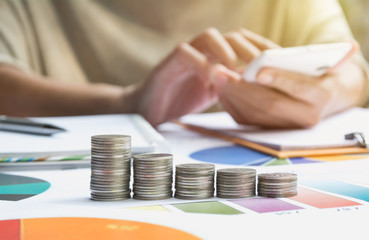 Wall Mural - Man using calculator with stock financial indices with stack coin. Financial stock market in accounting market economy analysis.