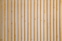 Wooden Vertical Slats Batten On A Light Gray Wall Background. Interior Detail, Texture, Background. The Concept Of Minimalism And Scandinavian Style In The Interior. Copy Space