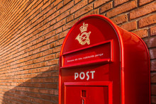 A Red Danish Mailbox On A Brick Wall
