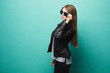 © innarevyako - Fashionable model girl, with slim shape, in leather jacket and sunglasses, posing at green background