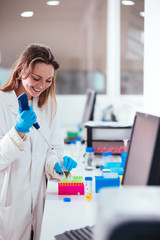Wall Mural - young woman scientist working with a pipette in a laboratory