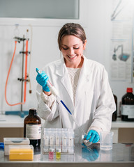 Wall Mural - young woman scientist working with a pipette in a laboratory