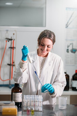 Wall Mural - young woman scientist working with a pipette in a laboratory